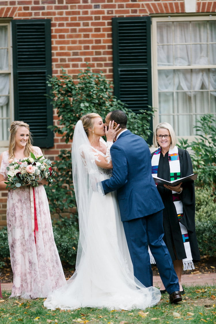 Bride and Groom Kissing, Heidi Gessner Wedding Officiant in Background