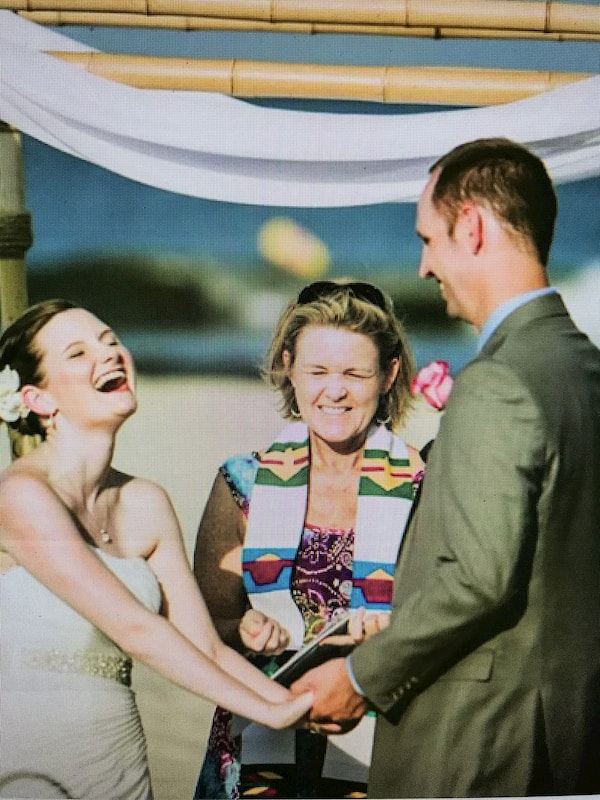 Bride Laughing with Wedding Officiant in Background